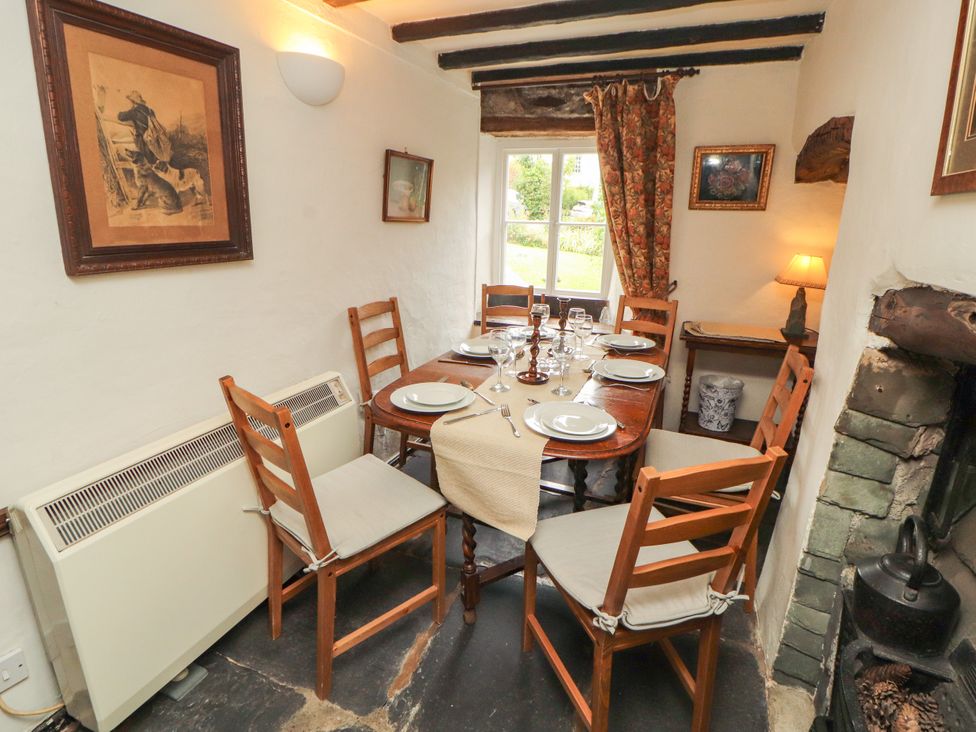 A dining room with a table set for dinner at Mill Cottage in Garnett Bridge