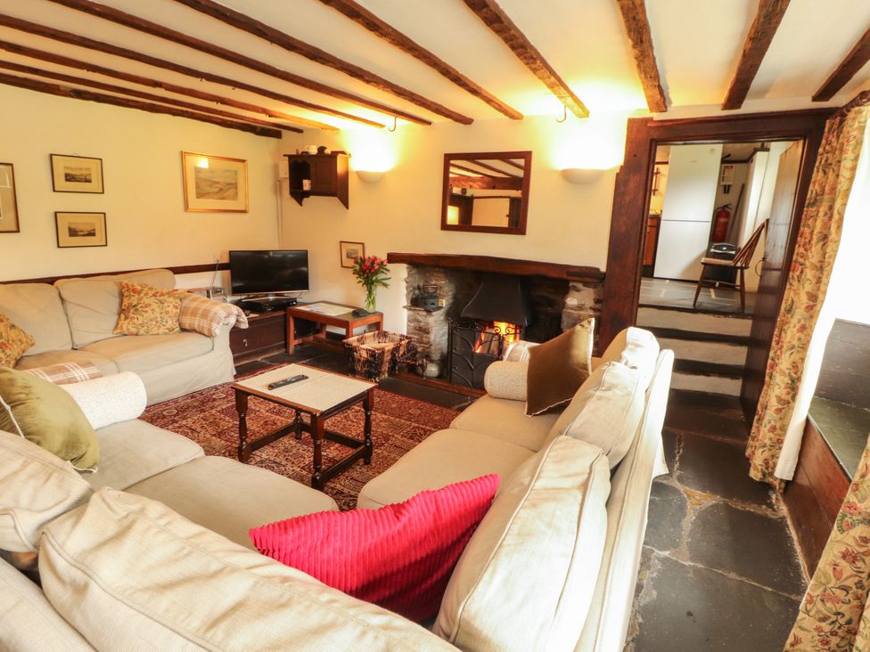A living room with a fireplace and sofa at Mill Cottage in Garnett Bridge