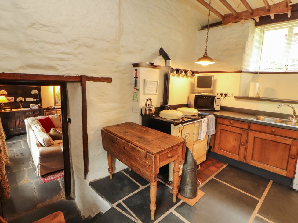 A kitchen with a stove, microwave, and sink at Mill Cottage in Garnett Bridge