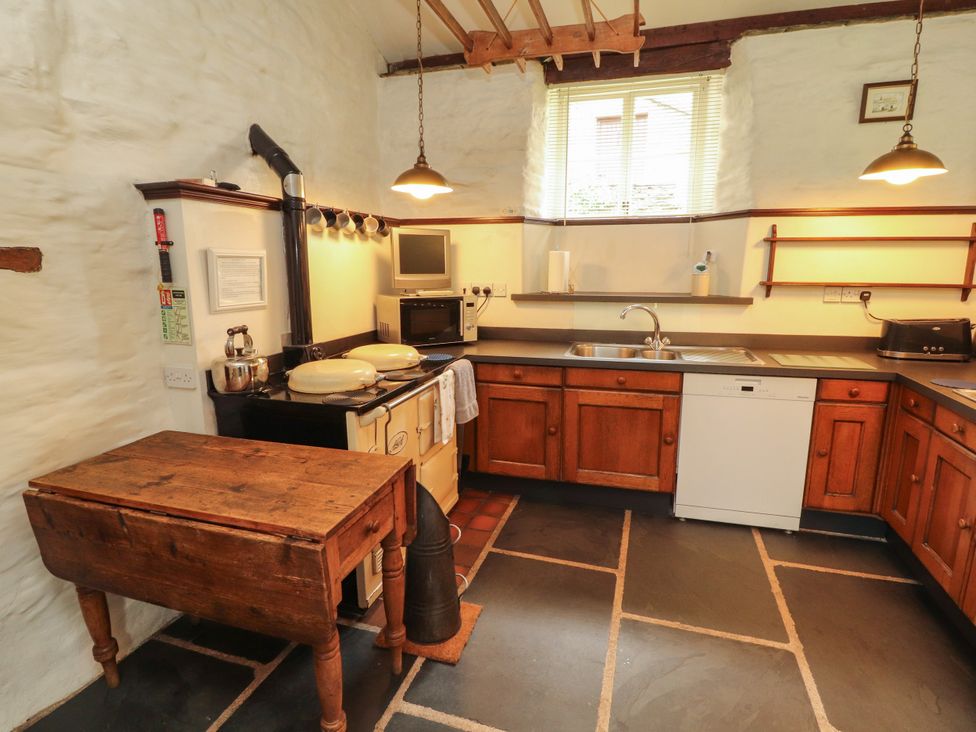 A kitchen with wooden cabinets and appliances at Mill Cottage in Garnett Bridge