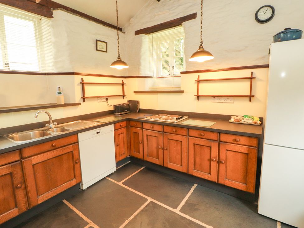 A kitchen with a sink and dishwasher at Mill Cottage in Garnett Bridge