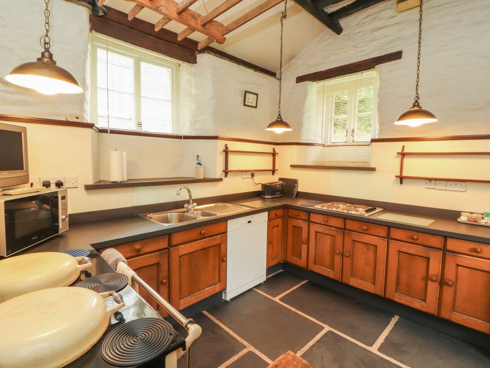 A kitchen with cabinets and appliances at Mill Cottage in Garnett Bridge