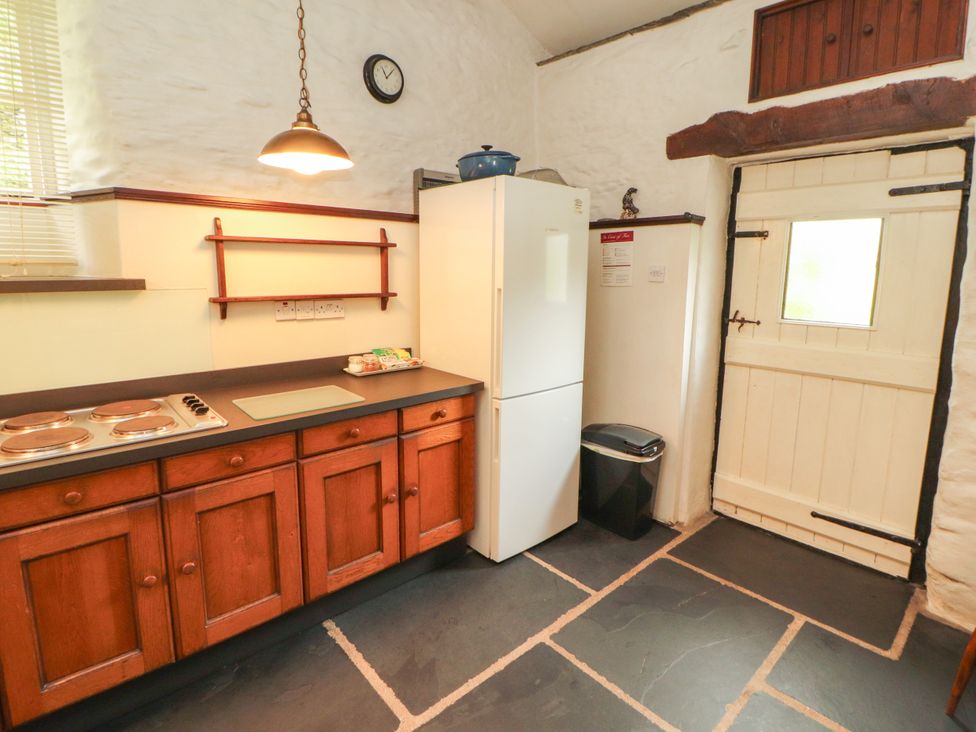 A kitchen with a fridge, oven and countertop at Mill Cottage in Garnett Bridge