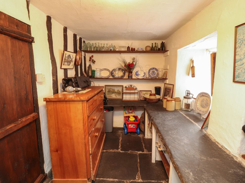 A kitchen with a dresser and shelves at Mill Cottage in Garnett Bridge