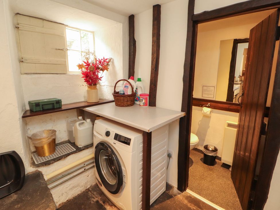 A laundry room with a washing machine and cleaning supplies at Mill Cottage in Garnett Bridge