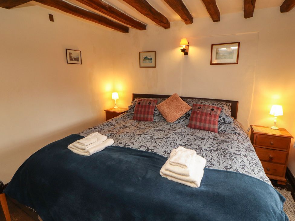 A bedroom with a bed and bedside tables at Mill Cottage Garnett Bridge