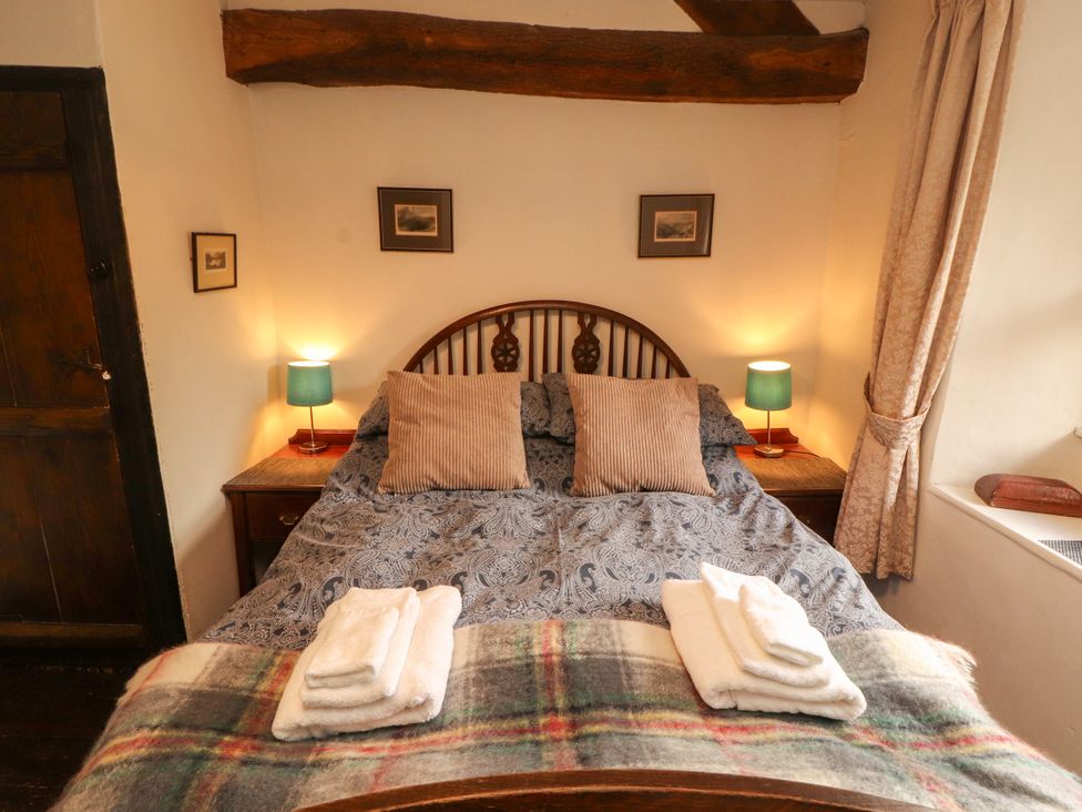 A bedroom with a bed and lamps at Mill Cottage in Garnett Bridge