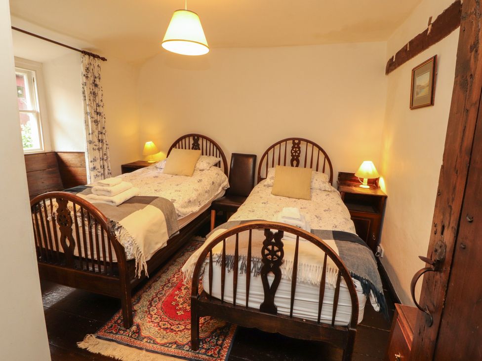 A bedroom with two beds and a window at Mill Cottage in Garnett Bridge
