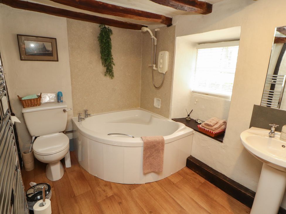 A bathroom with a bathtub and sink at Mill Cottage in Garnett Bridge