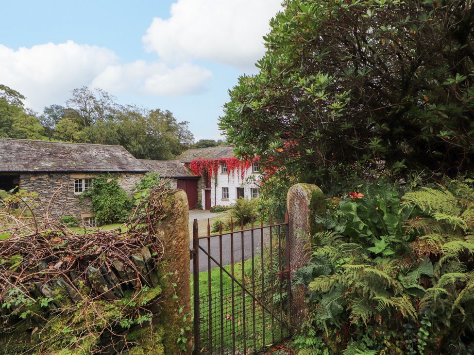 A house with a gate and foliage at Mill Cottage in Garnett Bridge