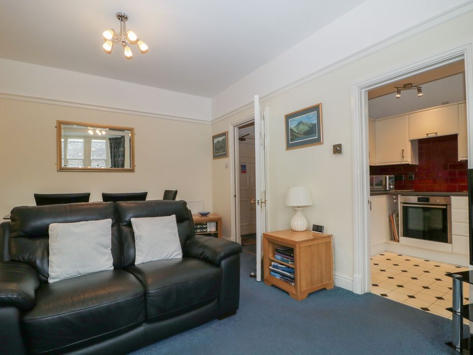 A living room with a sofa and a kitchen in the background at Amba, Keswick