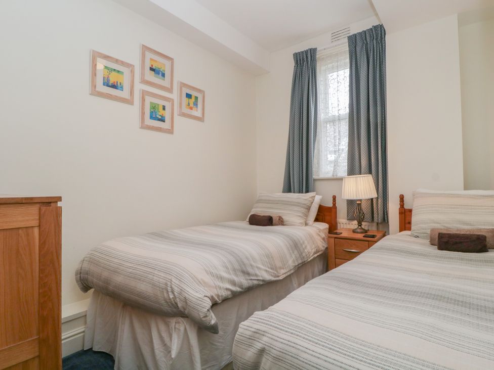 A bedroom with two beds and a bedside table at Amba in Keswick