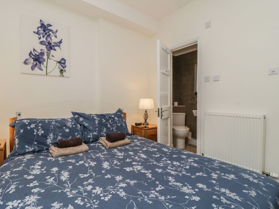 A bedroom with a bed and an ensuite bathroom at Amba in Keswick