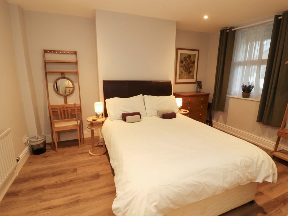 A bedroom with a bed and nightstands at Archers in Keswick