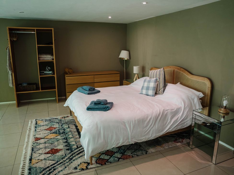 A bedroom with a bed and wardrobe at The Heronry, Longtown
