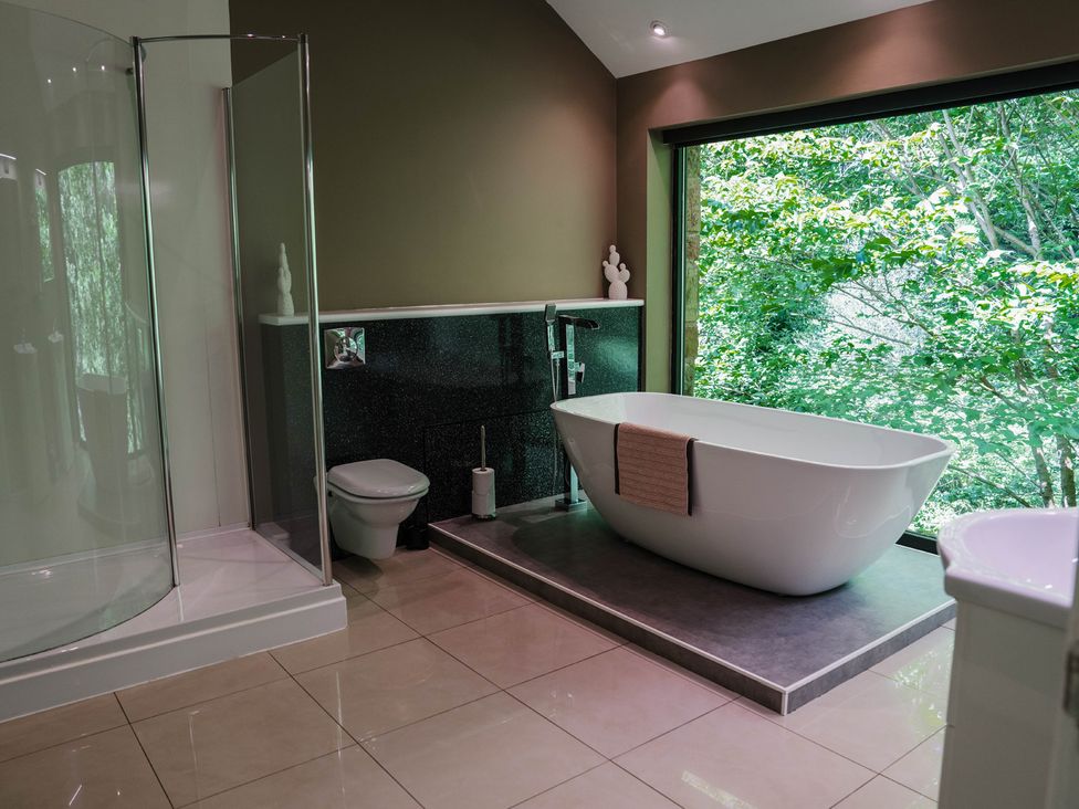 A bathroom with a bathtub and shower at The Heronry in Longtown