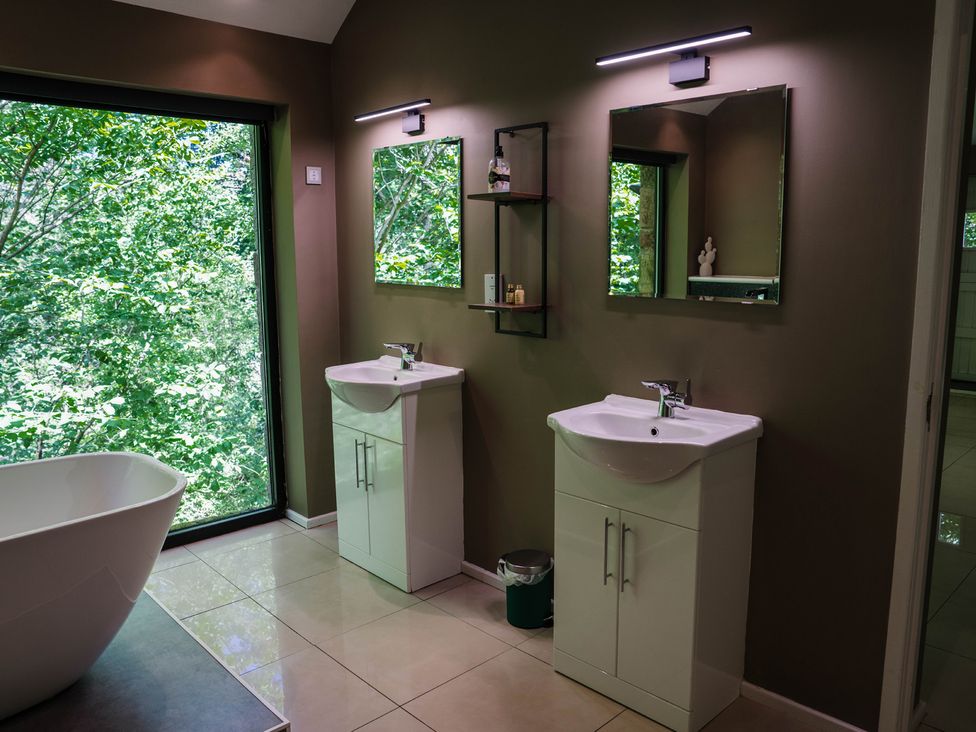 A bathroom with two washbasins and a bathtub at The Heronry in Longtown
