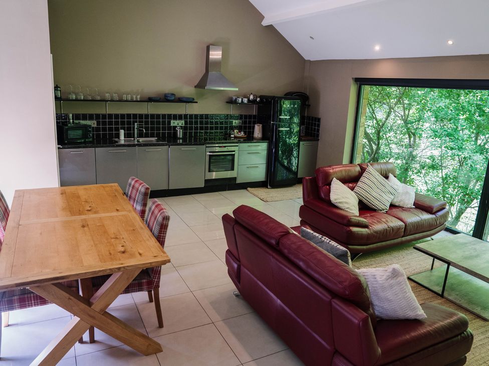 A kitchen and living room with a dining area at The Heronry in Longtown