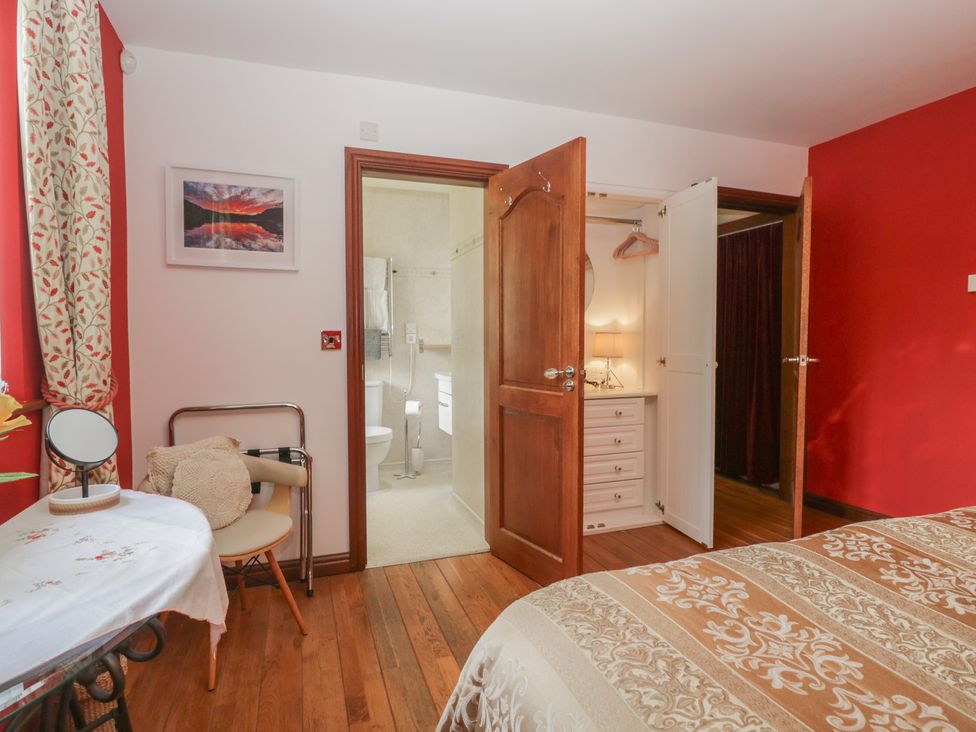 A bedroom with a bed and a connecting bathroom at Stonegarth Cottage Grasmere