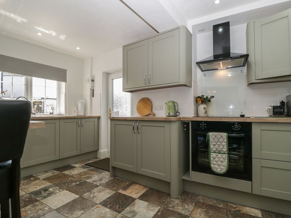 A kitchen with cabinets and appliances at Fountain Cottage in Keswick