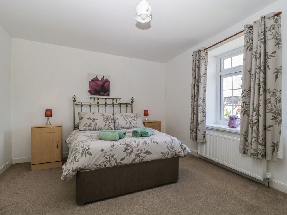 A bedroom with a bed and bedside tables at Fountain Cottage in Keswick