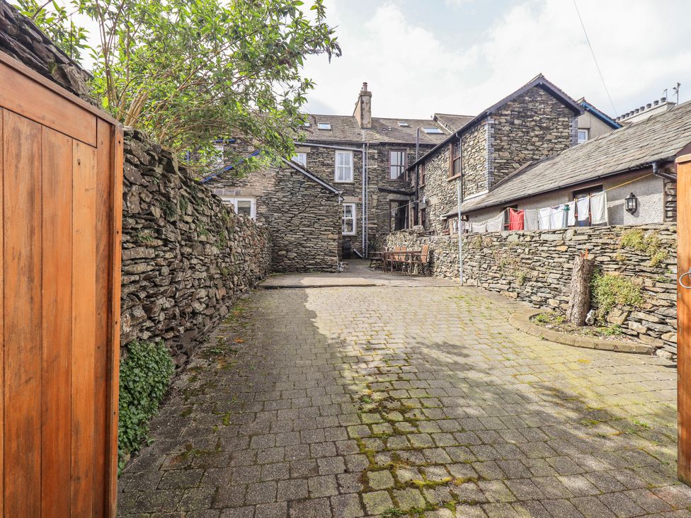 A garden with stone walls and a paved pathway at Ingle Burrow in Windermere