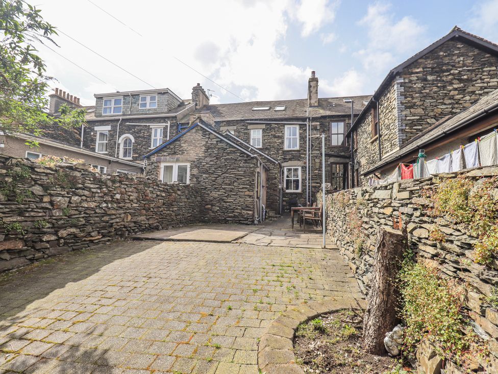 A garden with stone walls and a wooden table at Ingle Burrow Windermere