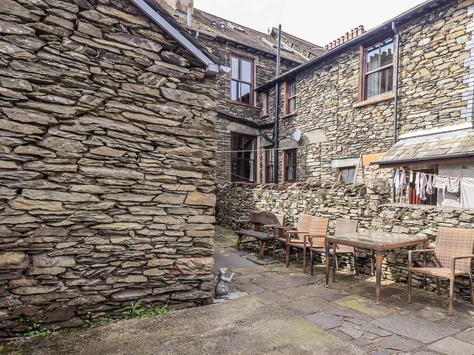 An outdoor area with stone walls and furniture at Ingle Burrow in Windermere