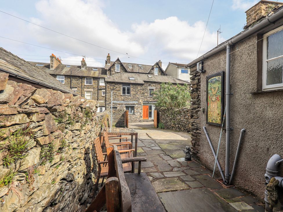 An outdoor area with a stone wall and benches at Ingle Burrow in Windermere