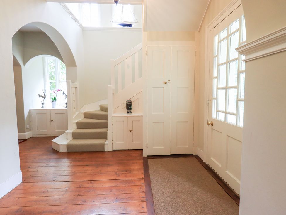 A hallway with a staircase and window at Little Ellers, Portinscale near Keswick