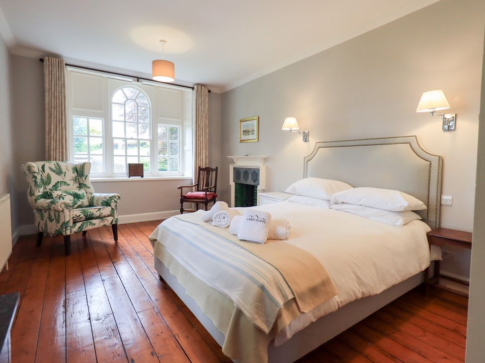 A bedroom with a bed and a chair at Little Ellers in Portinscale near Keswick