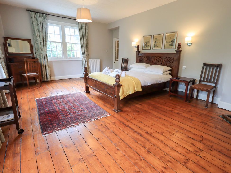 A bedroom with a bed and wooden furniture at Little Ellers in Portinscale near Keswick