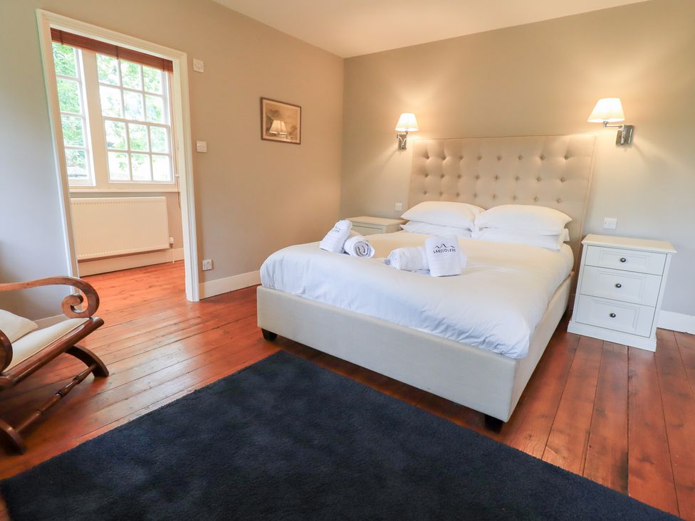 A bedroom with a bed and a rocking chair at Little Ellers in Portinscale near Keswick