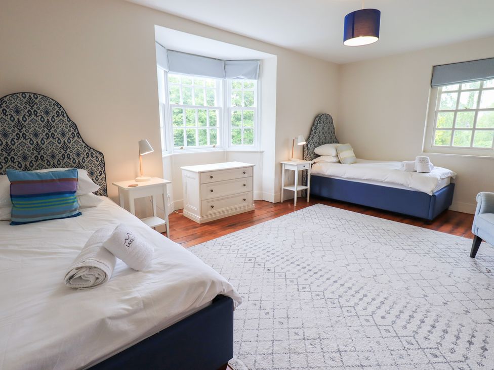 A bedroom with two beds and a chest of drawers at Little Ellers in Portinscale near Keswick