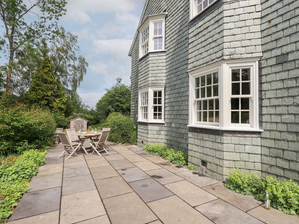 An outdoor patio area with a table and chairs at Little Ellers in Portinscale near Keswick