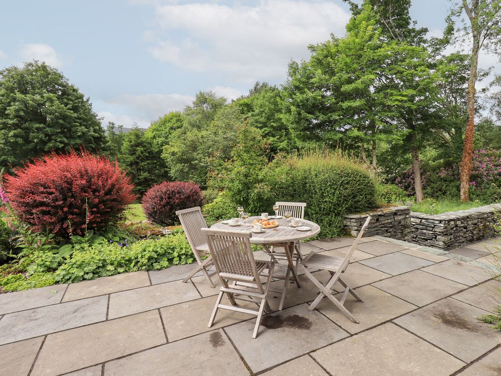 A garden with a table and chairs surrounded by plants at Little Ellers Portinscale near Keswick