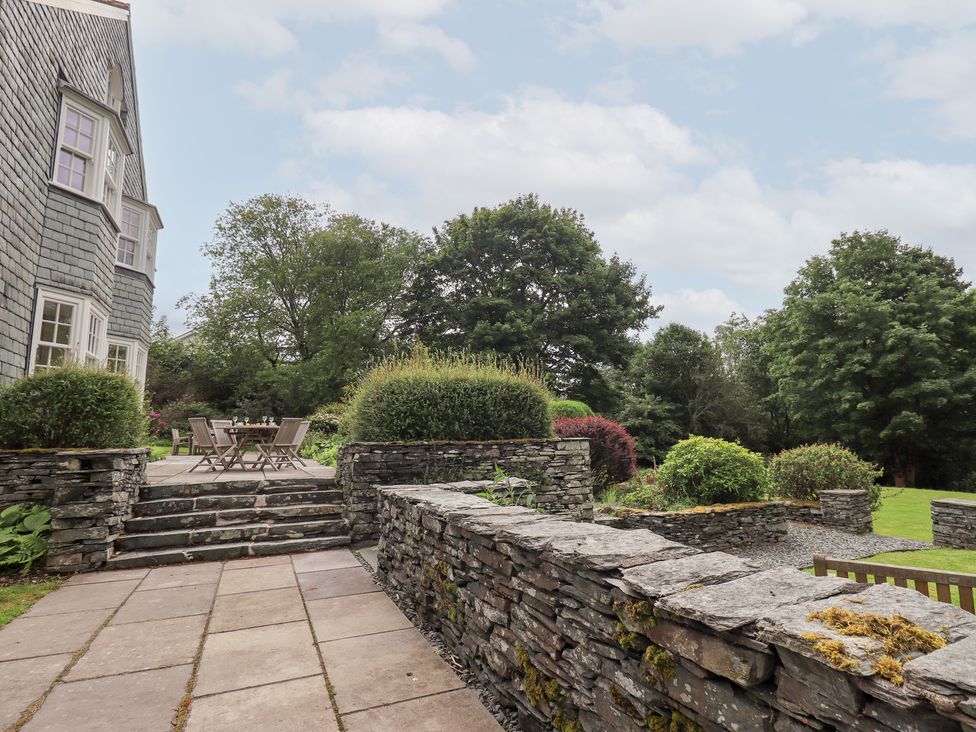 A garden with stone wall and seating area at Little Ellers in Portinscale near Keswick