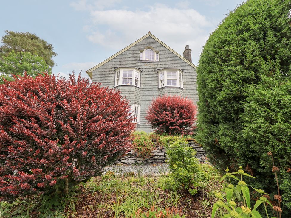 A house with bushes and trees in the garden at Little Ellers in Portinscale near Keswick