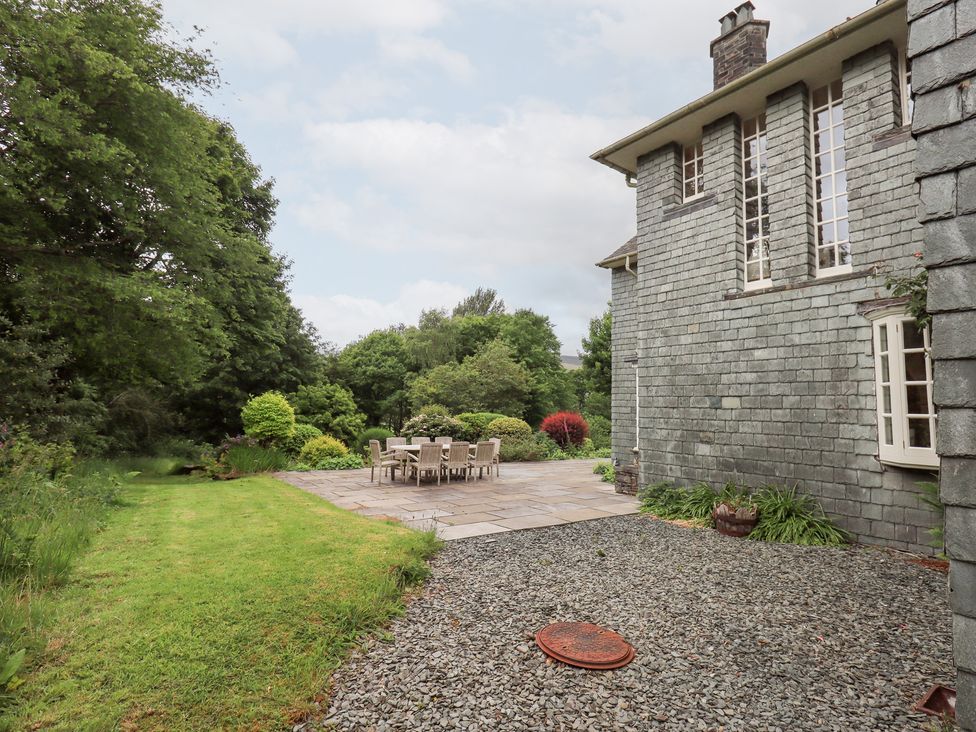 A garden with a table and chairs on a patio at Little Ellers in Portinscale near Keswick