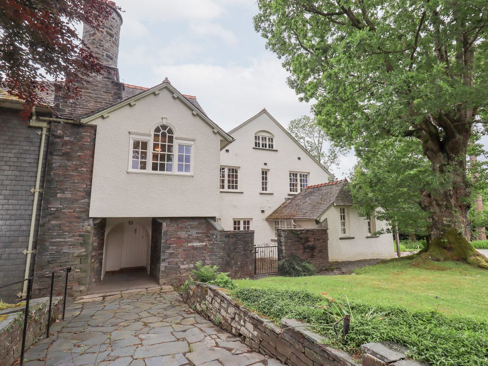 An exterior view of a house with a pathway and trees at Little Ellers in Portinscale near Keswick