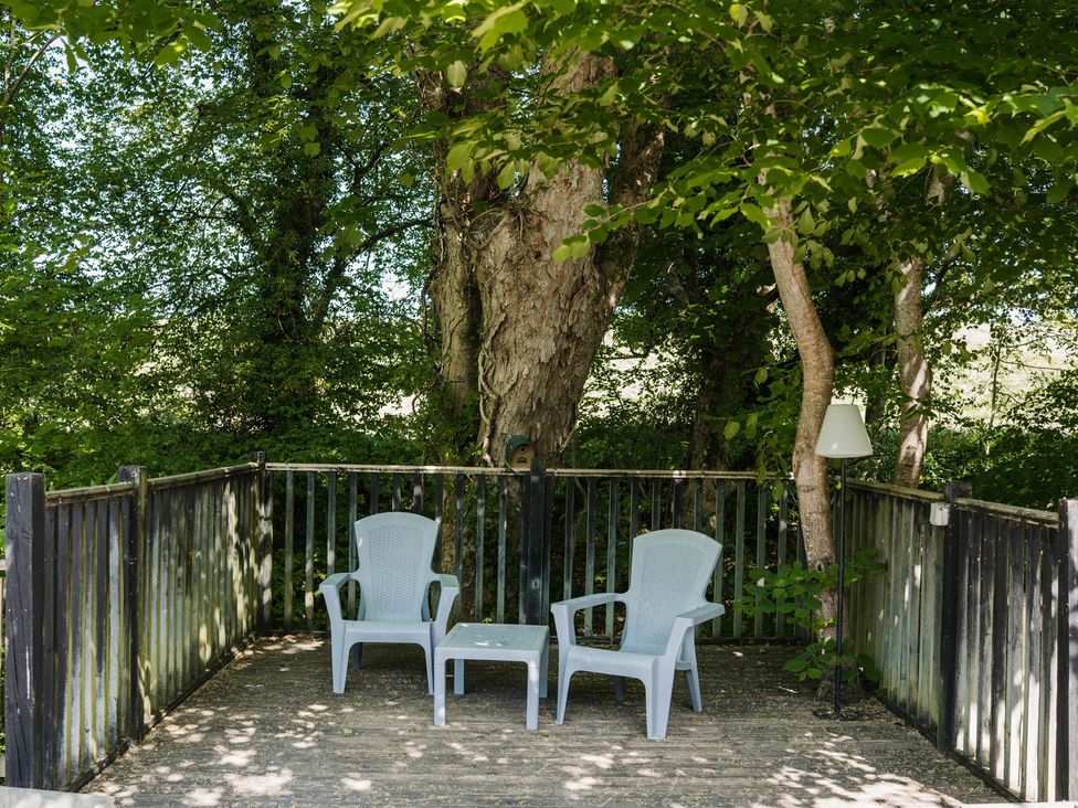 An outdoor seating area with two chairs and a table at The Snug in Longtown