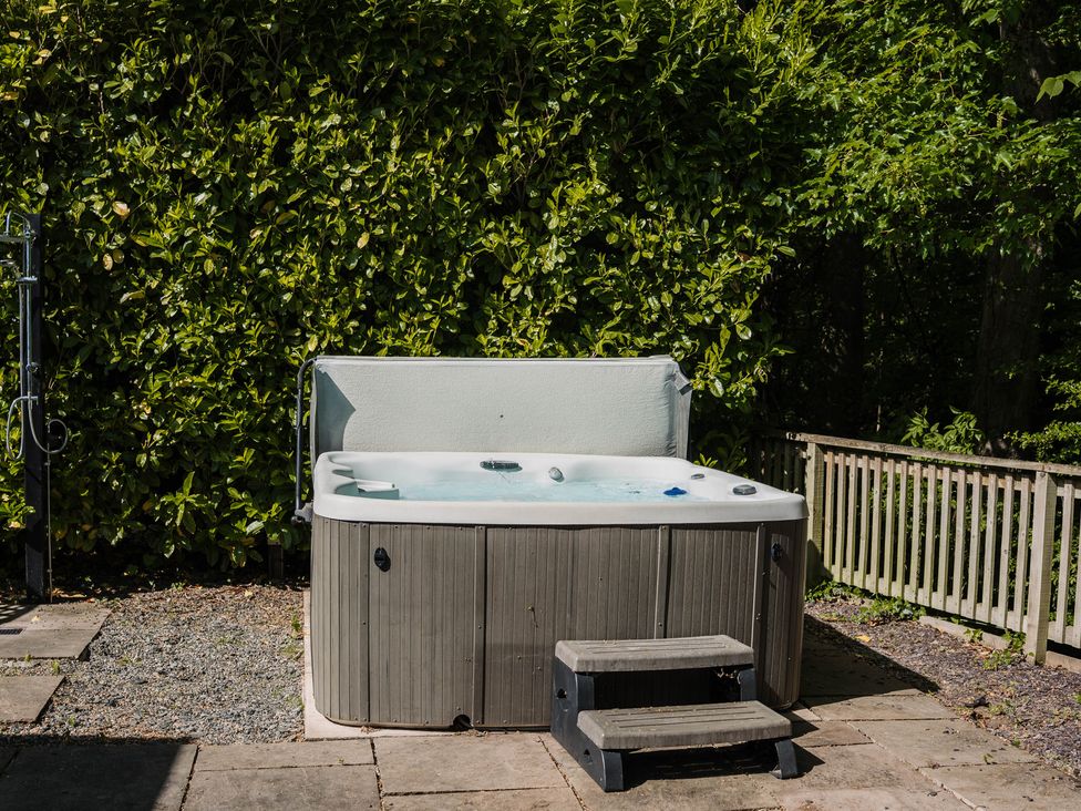A hot tub with steps beside a fence at The Snug in Longtown