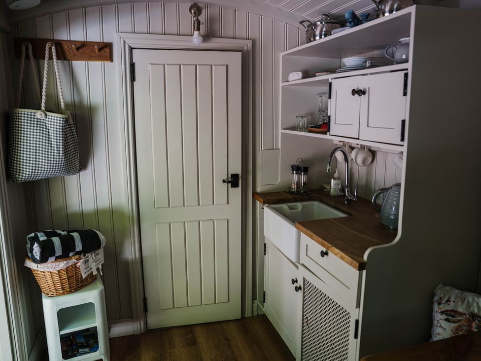 A kitchen with a sink and storage at The Snug in Longtown