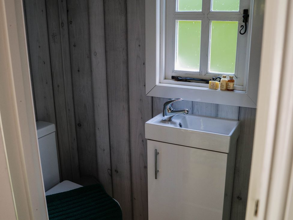 A bathroom with a toilet and sink at The Snug in Longtown