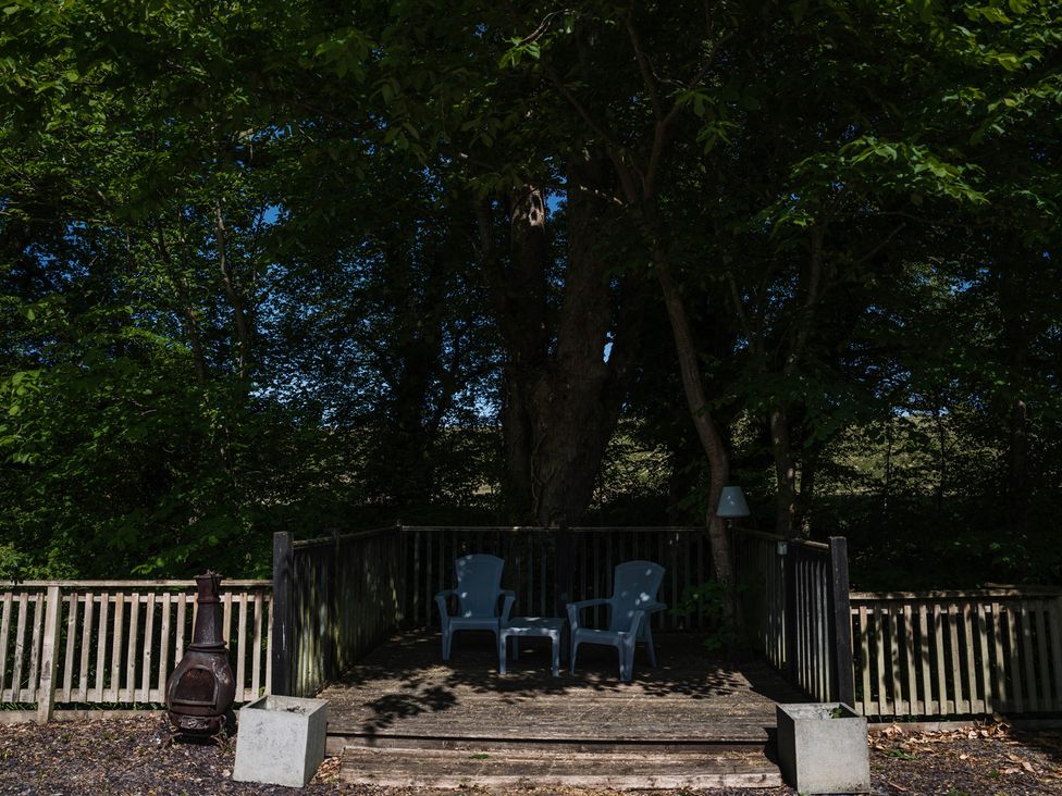 An outdoor area with two chairs and a fire pit at The Snug in Longtown