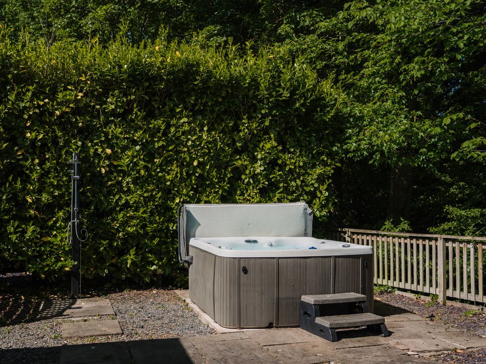 A hot tub with steps in a garden at The Snug Longtown