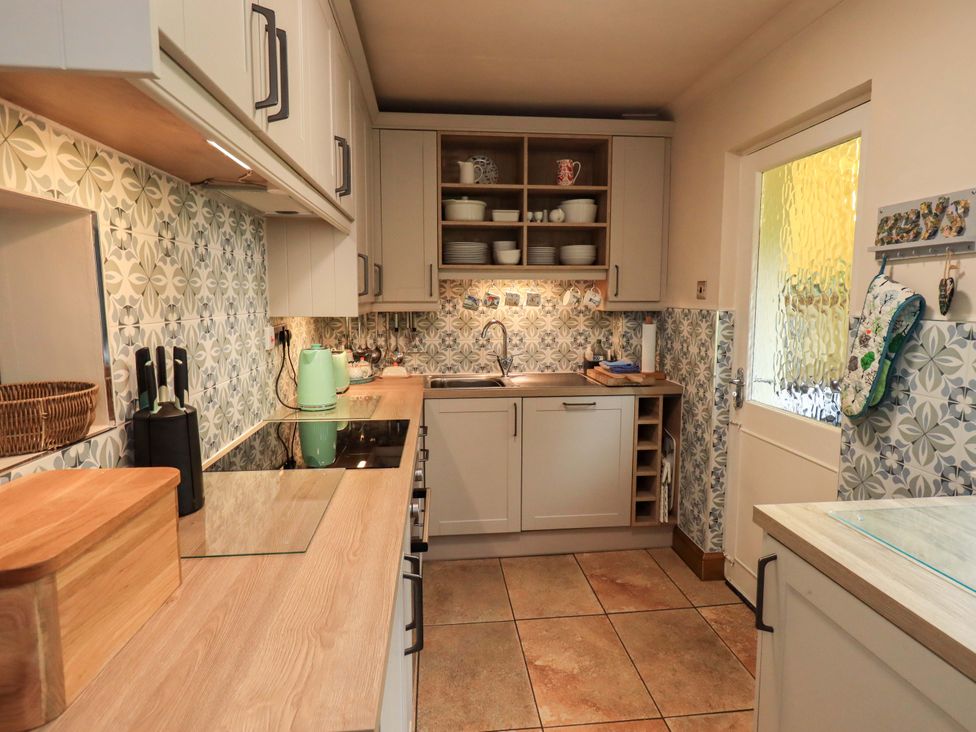 A kitchen with cabinets and a sink at Foresters Cottage in Satterthwaite