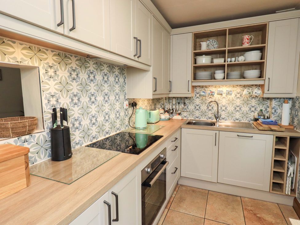 A kitchen with sink and stove at Foresters Cottage in Satterthwaite