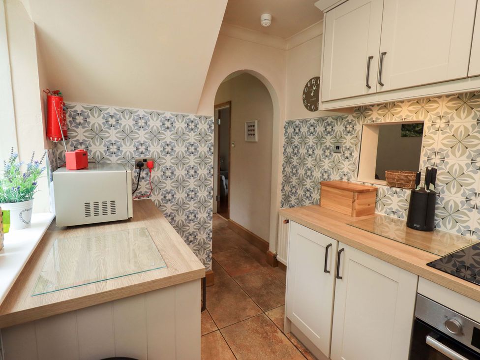 A kitchen with a microwave and sink at Foresters Cottage in Satterthwaite