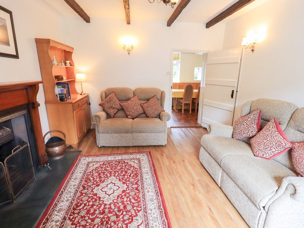 A living room with sofas and a fireplace at Millcroft in Glenridding